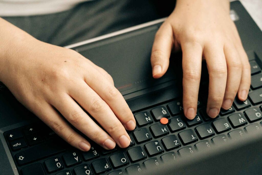 Close-up of a person typing on a keyboard