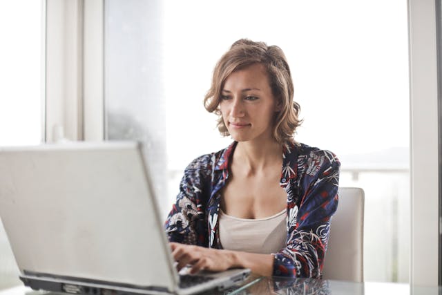 A woman using her grey laptop